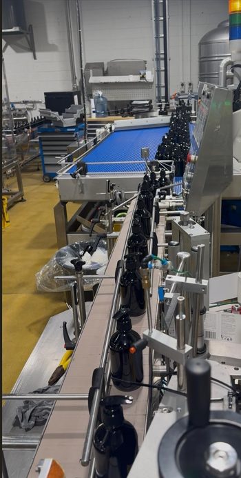 Bottle labelling line with conveyor and applicator heads